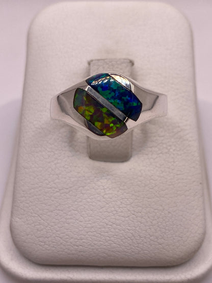 Anillo de plata .925 con ópalo de fuego multicolor mostrando juego azul verdoso