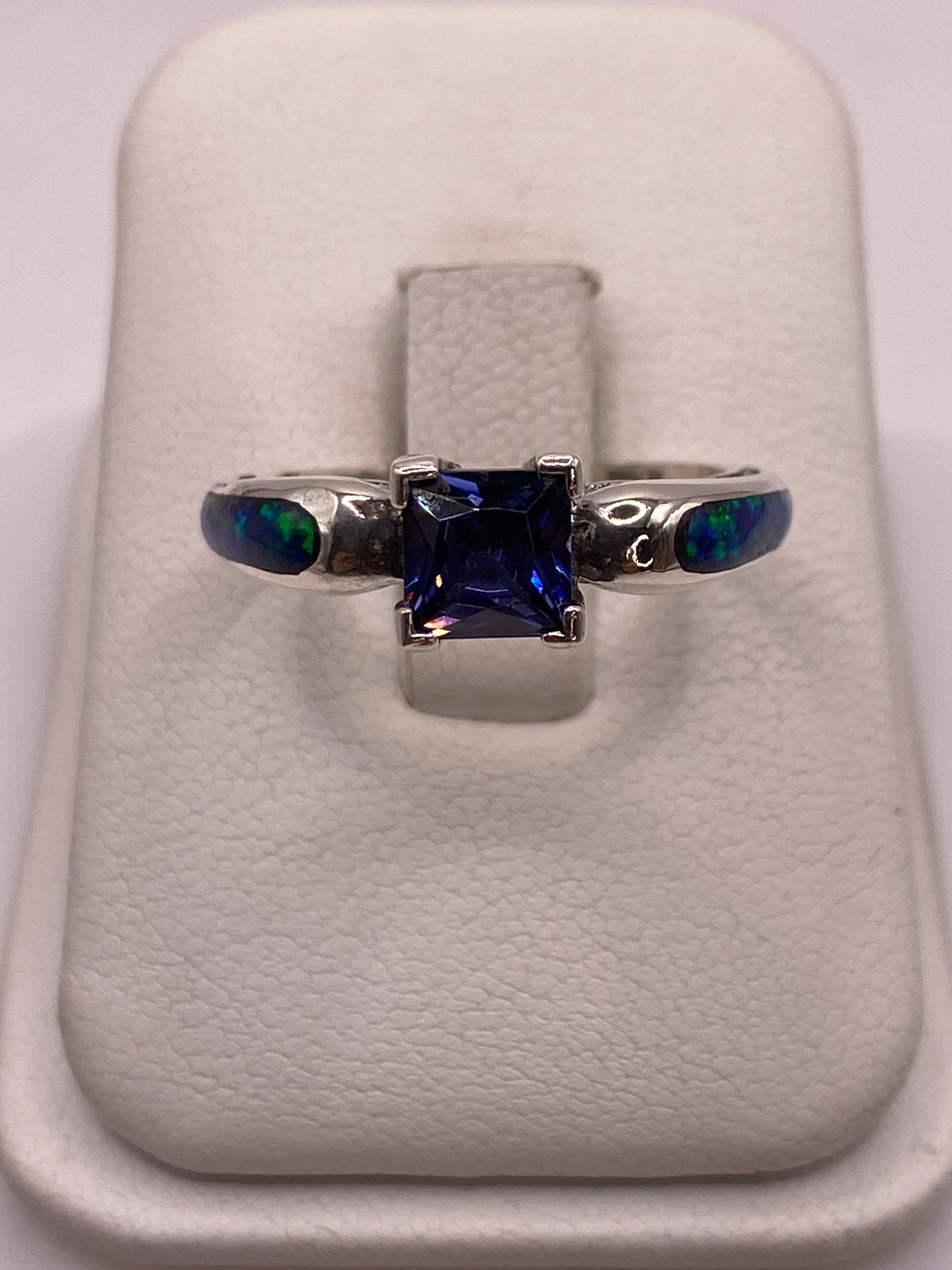 Anillo de plata con ópalo de fuego azul en estuche de presentación, frente vista superior