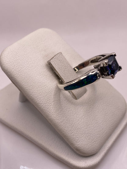 Anillo solitario en plata .925 con ópalo de fuego azul desde la lateral, mostrando el engaste