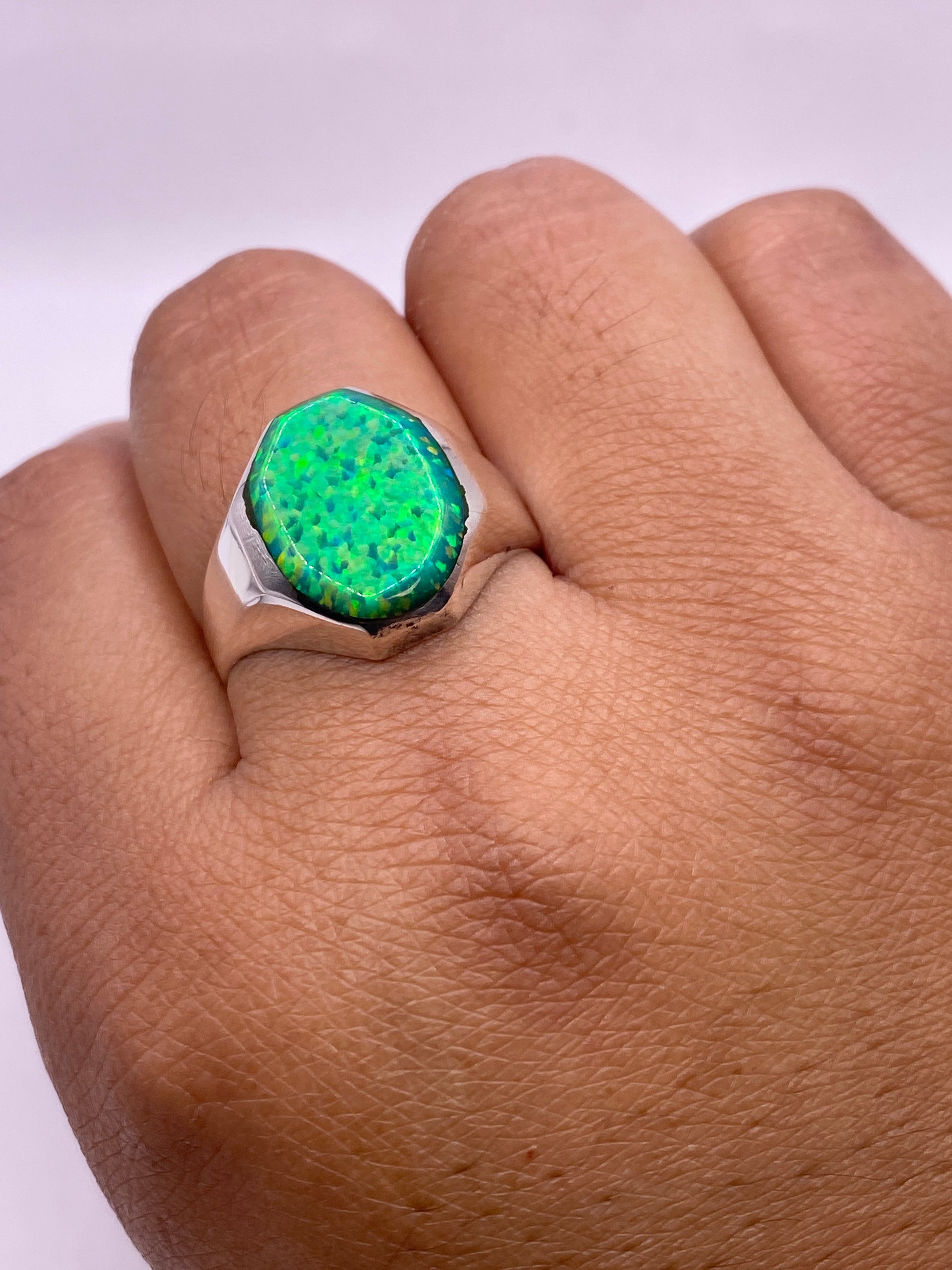 Anillo puesto en dedo mostrando el brillo natural y dinamismo del ópalo verde