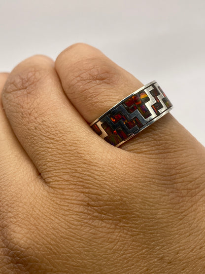 Anillo de ópalo de fuego en mano, exhibiendo el patrón geométrico y la profundidad del color multicolor de la piedra