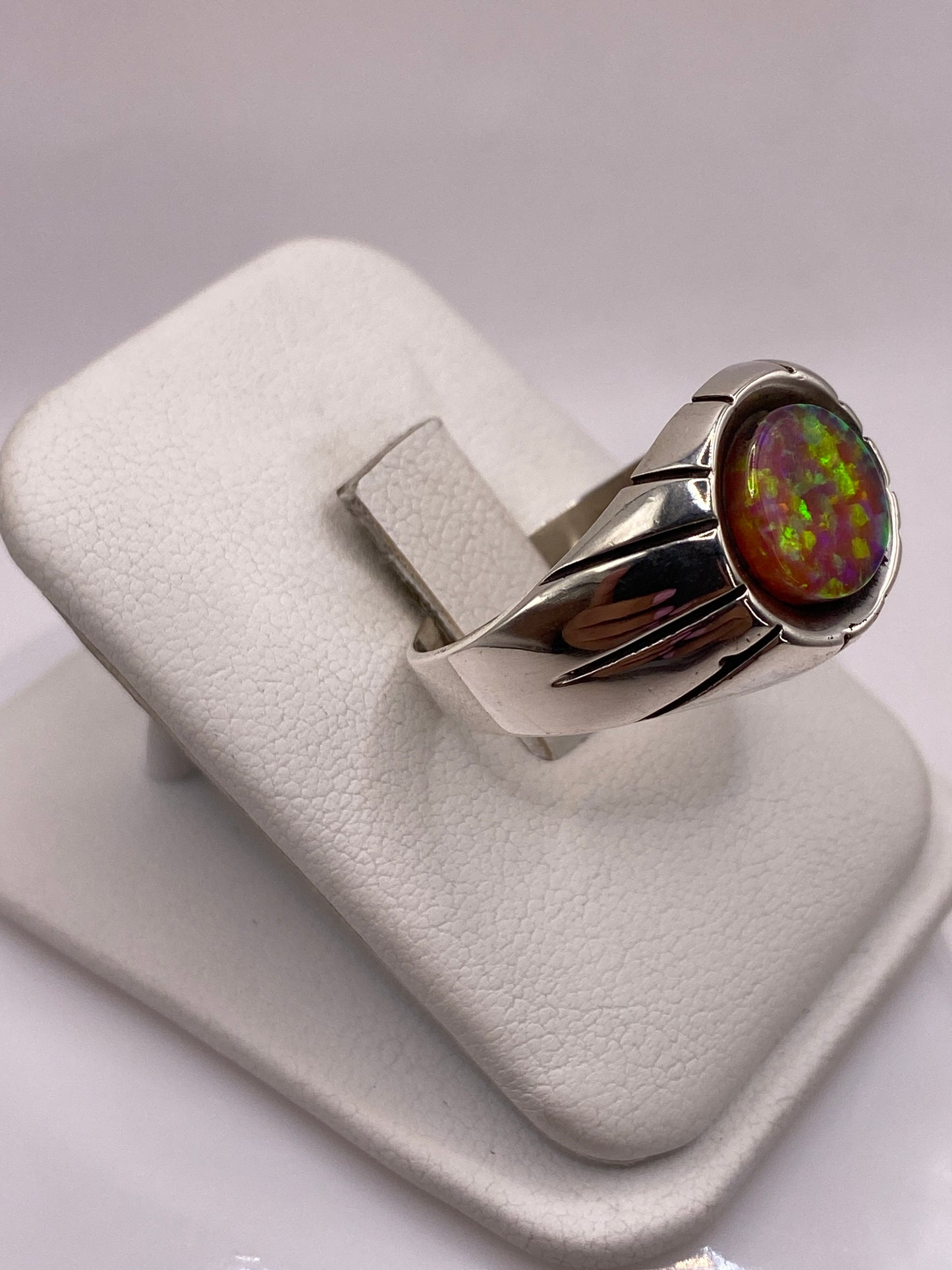 Detalle lateral del anillo mostrando las bandas pulidas y el juego de color del ópalo