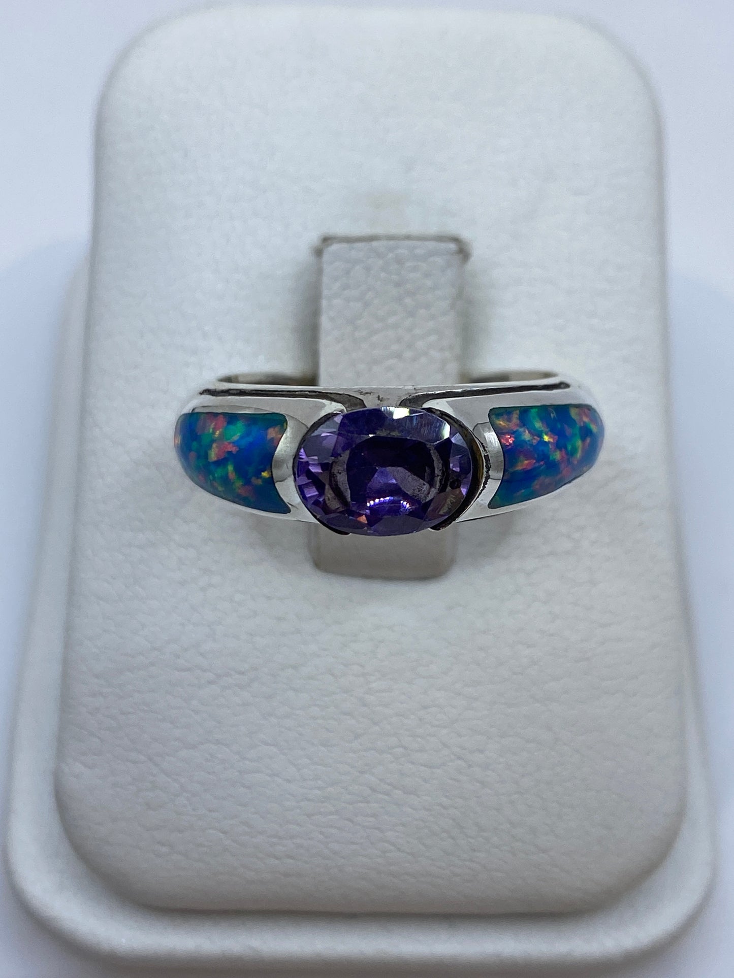 Anillo de plata .950 con ópalo de fuego multicolor, mostrando reflejos rojos, naranjas y verdes sobre fondo blanco