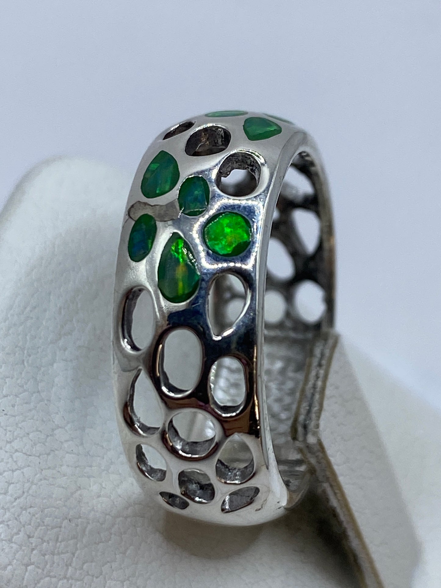 Detalle lateral del anillo calado en plata con engaste de ópalo de fuego natural