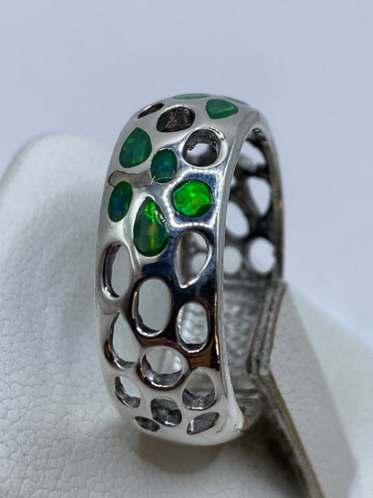 Detalle lateral del anillo calado en plata con engaste de ópalo de fuego natural