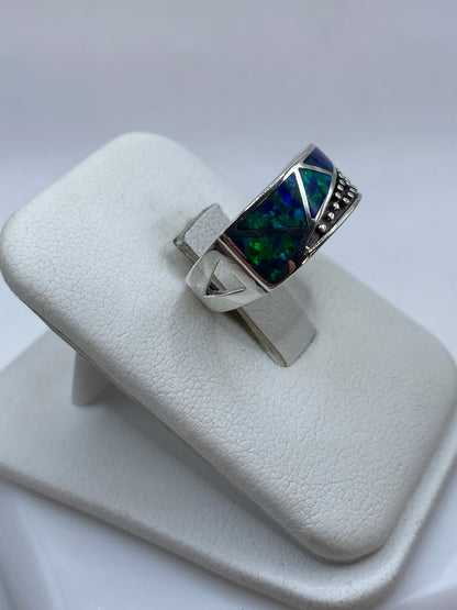 Detalle frontal del ópalo azul con destellos verdes en anillo de plata pura