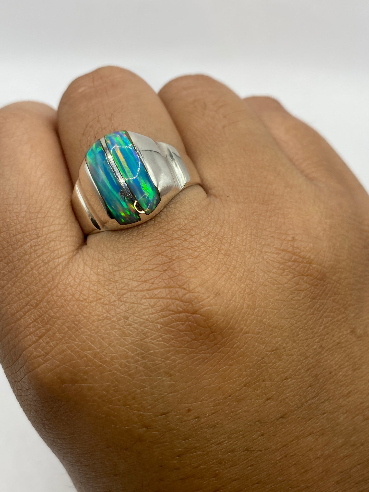Anillo puesto en mano mostrando el brillo y profundidad del ópalo natural