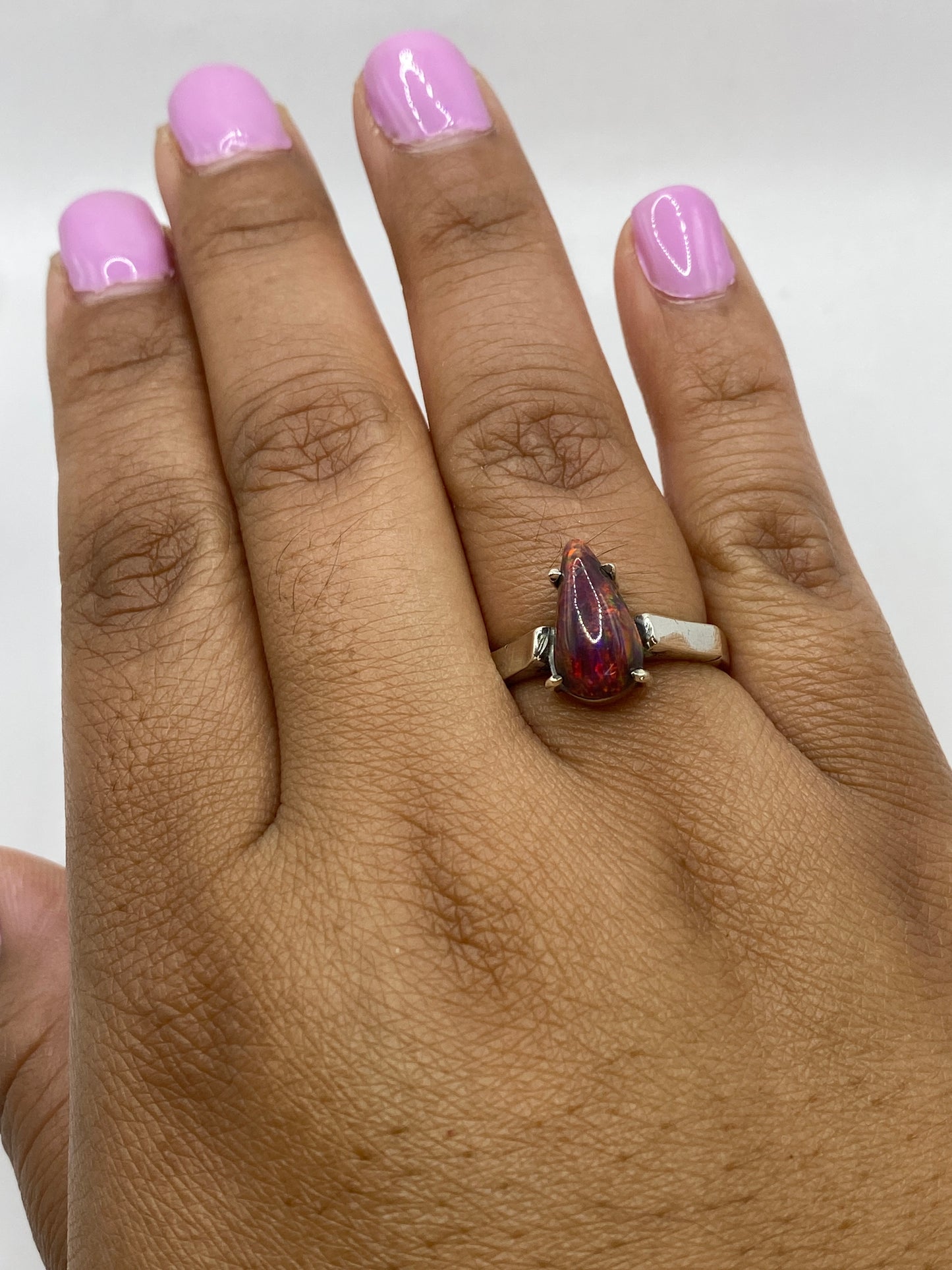 Anillo de ópalo de fuego en dedo de mujer con sello .950 y fuego de la gema visible