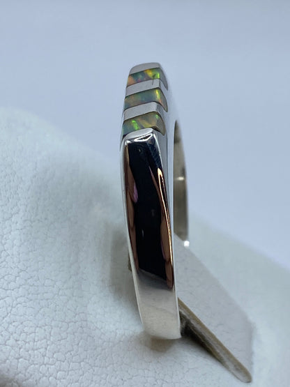 Anillo en la mano mostrando el diseño escalonado y el brillo del ópalo