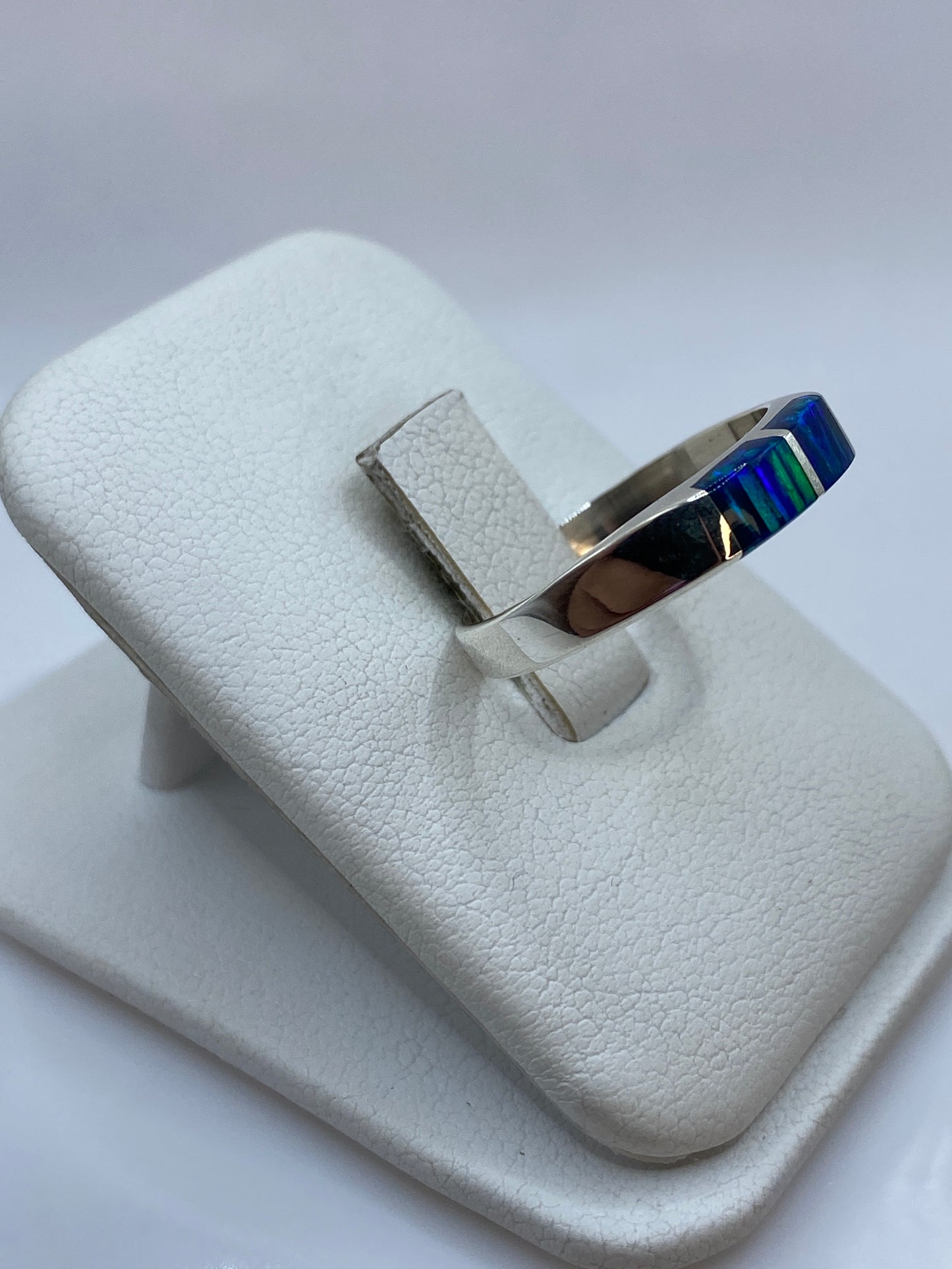 Detalle del juego de colores del ópalo azul en el engaste de plata