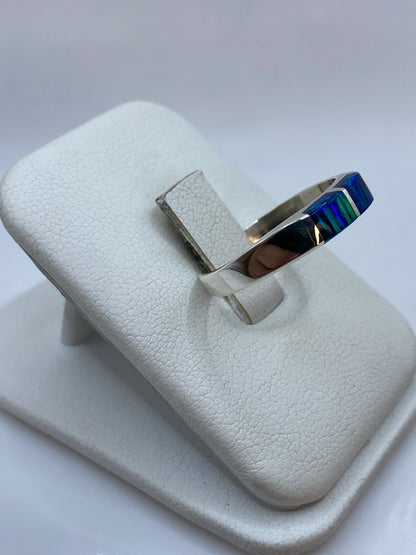 Detalle del juego de colores del ópalo azul en el engaste de plata