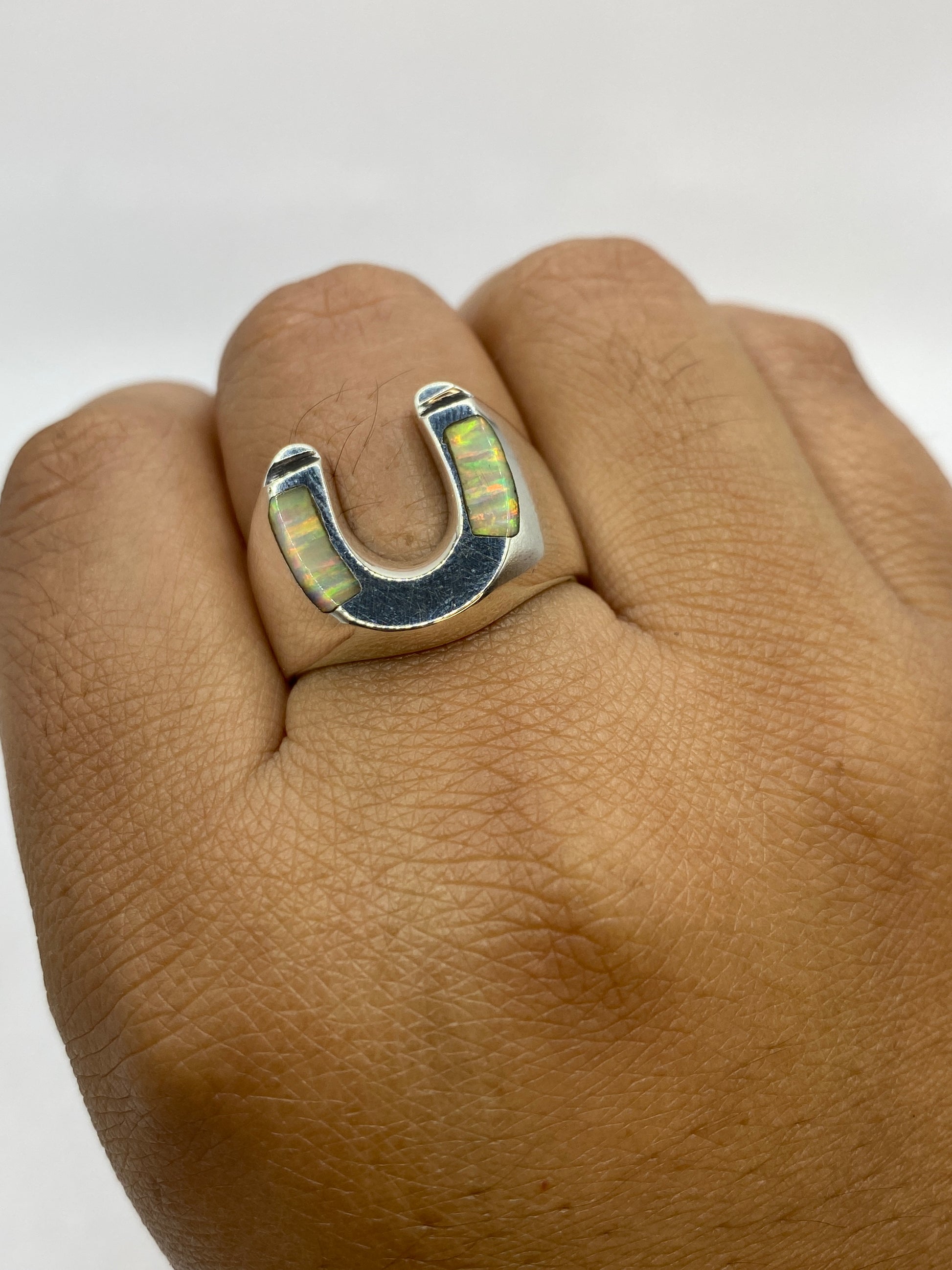Anillo en dedo mostrando presencia real y brillo del Ópalo bajo luz natural