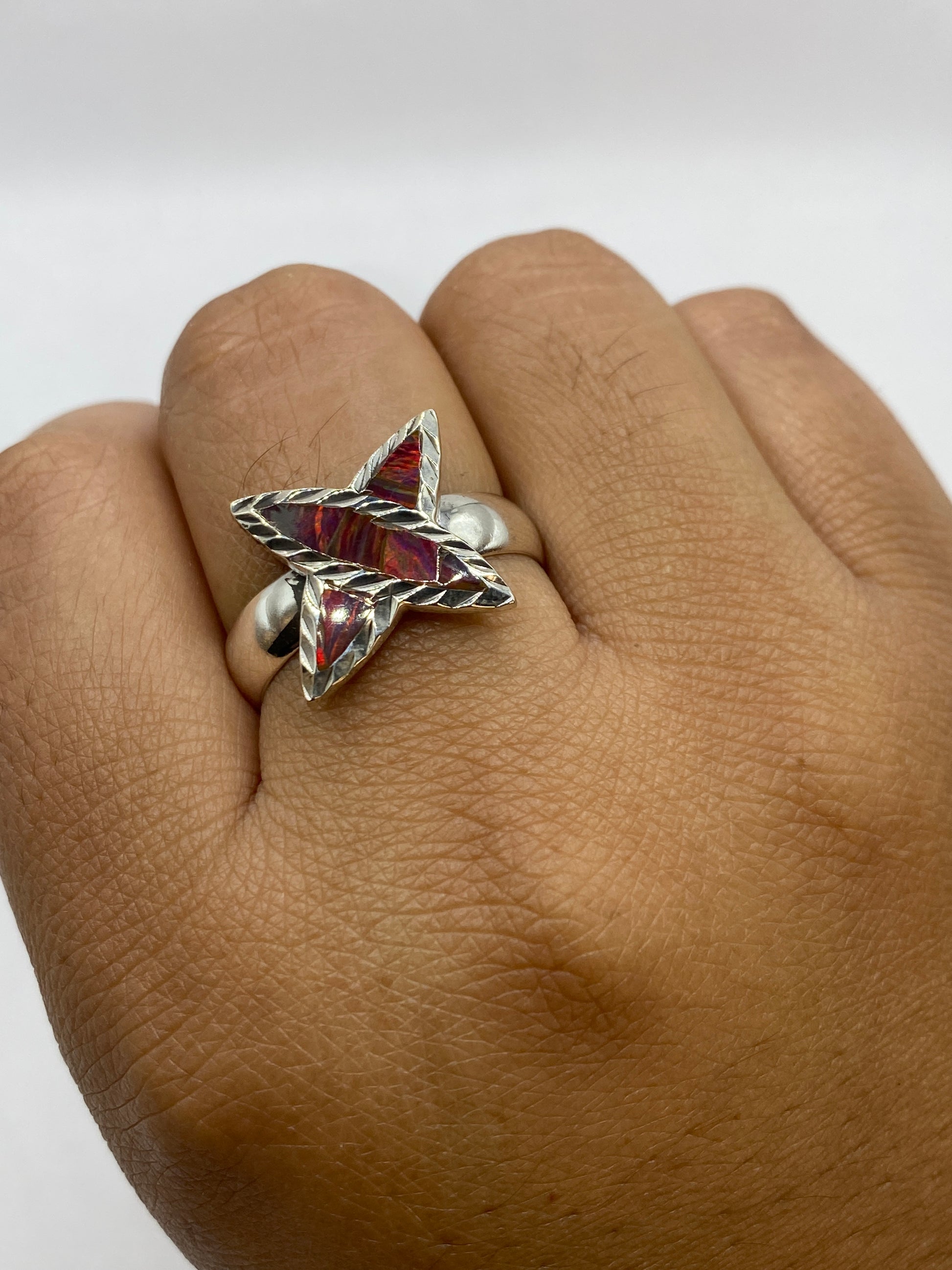 Anillo de ópalo de fuego en mano, evidenciando el cambio de color según la luz