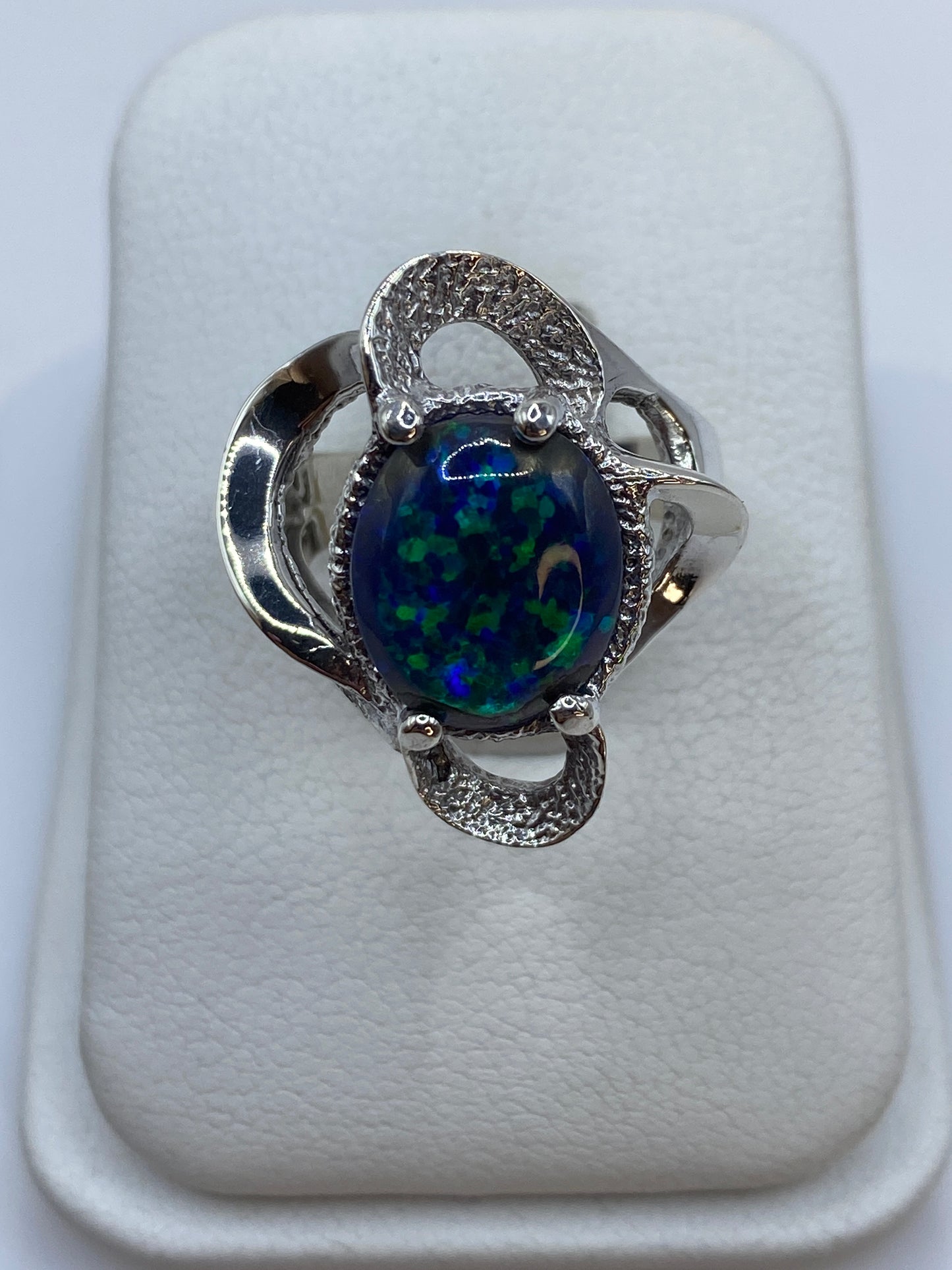 Anillo de plata con ópalo de fuego azul en talla pequeña sobre fondo blanco