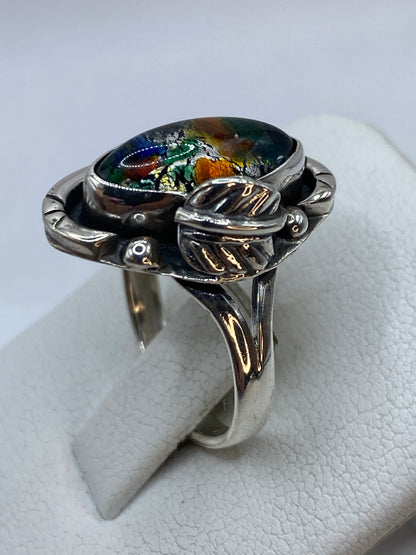 Piedra multicolor con fuego intenso en tonos verdes, ámbar y dorado