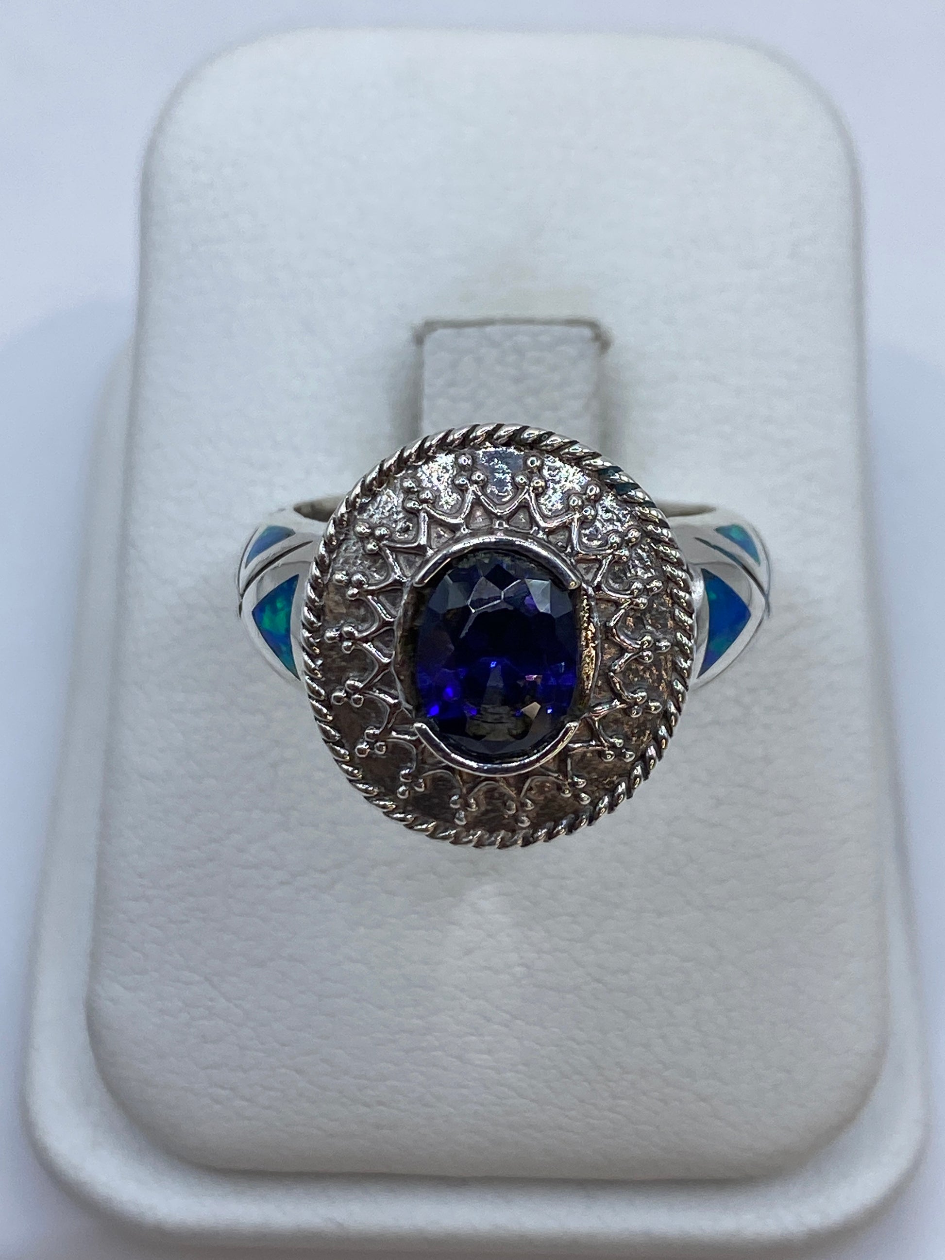Anillo solitario de plata .950 con ópalo de fuego azul, visto desde arriba en estuche blanco