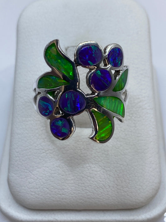 Anillo de plata .925 con ópalo de fuego morado en diseño floral sobre estuche blanco