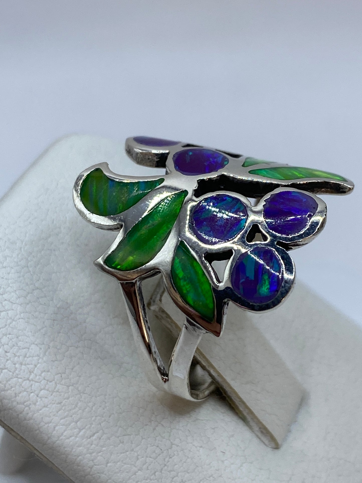 Detalle del ópalo de fuego morado con brillo natural y hojas de plata artesanales