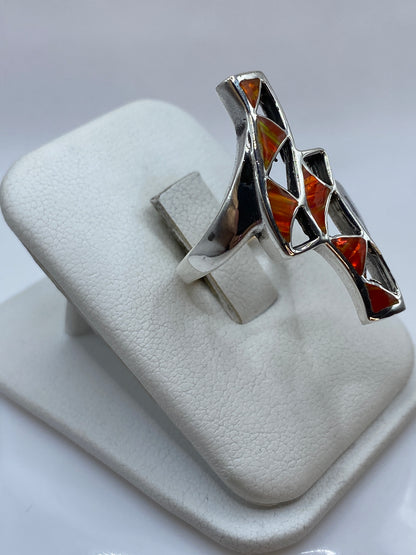 Detalle lateral del anillo mostrando la profundidad del ópalo y el fuego naranja-rojo