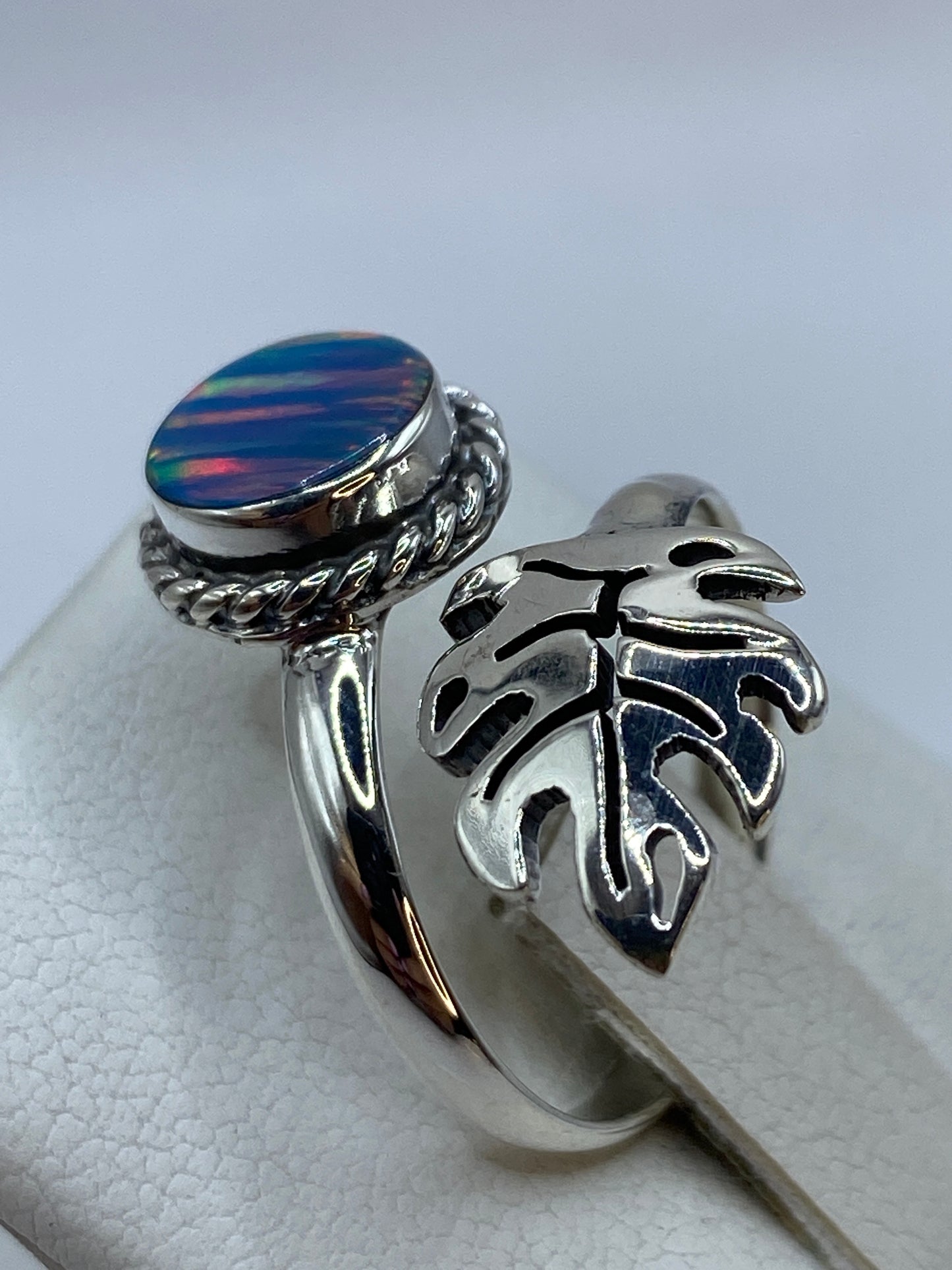 Anillo ajustable de diseño étnico con ópalo azul puesto en dedo, detalle del fuego del ópalo