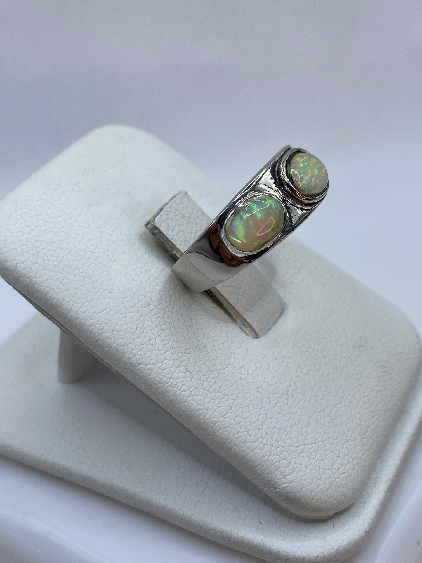 Anillo de plata .925 con ópalo de fuego en talla 5, mostrando juego de colores verdes y naranjas