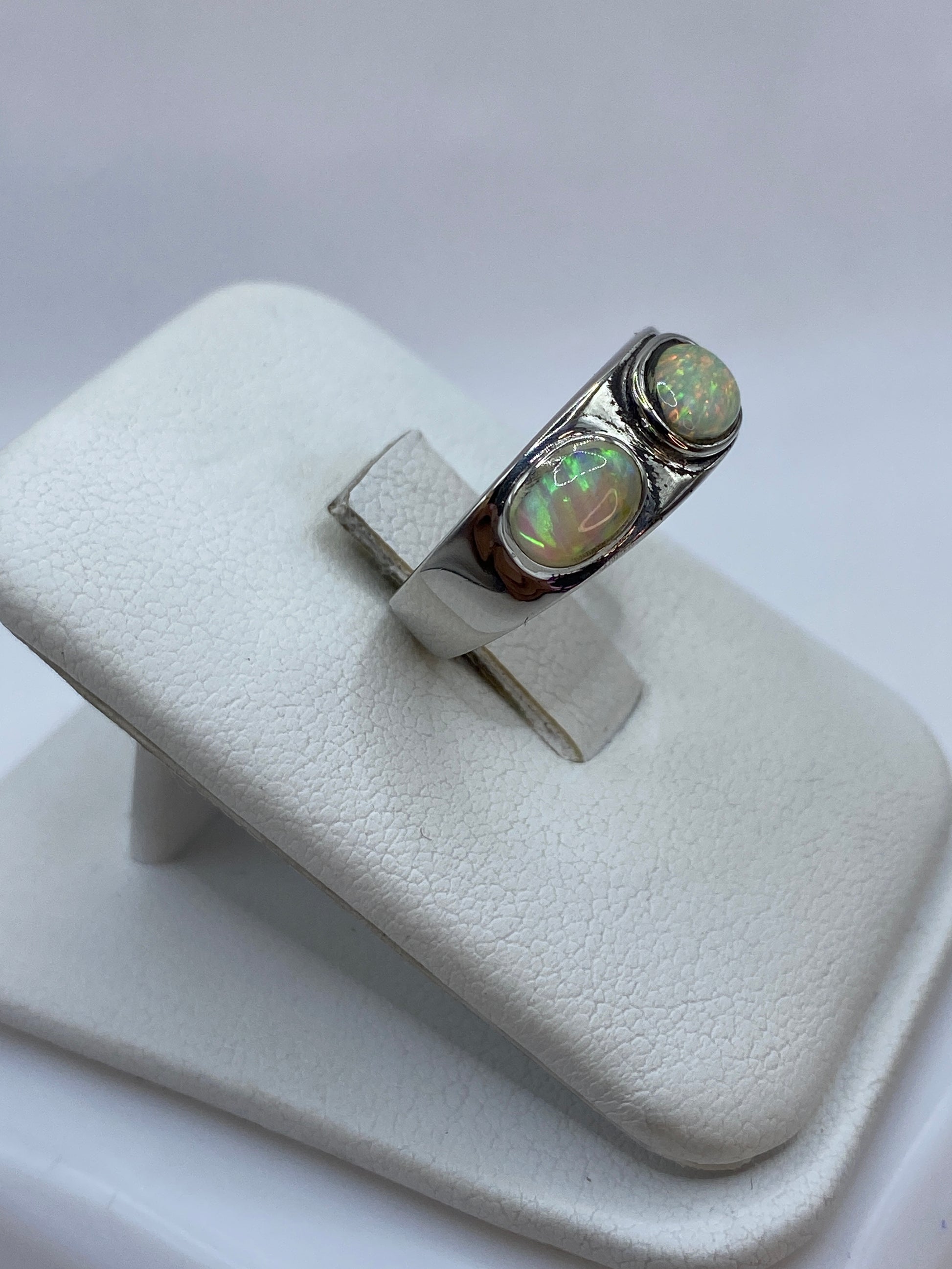 Anillo de plata .925 con ópalo de fuego en talla 5, mostrando juego de colores verdes y naranjas