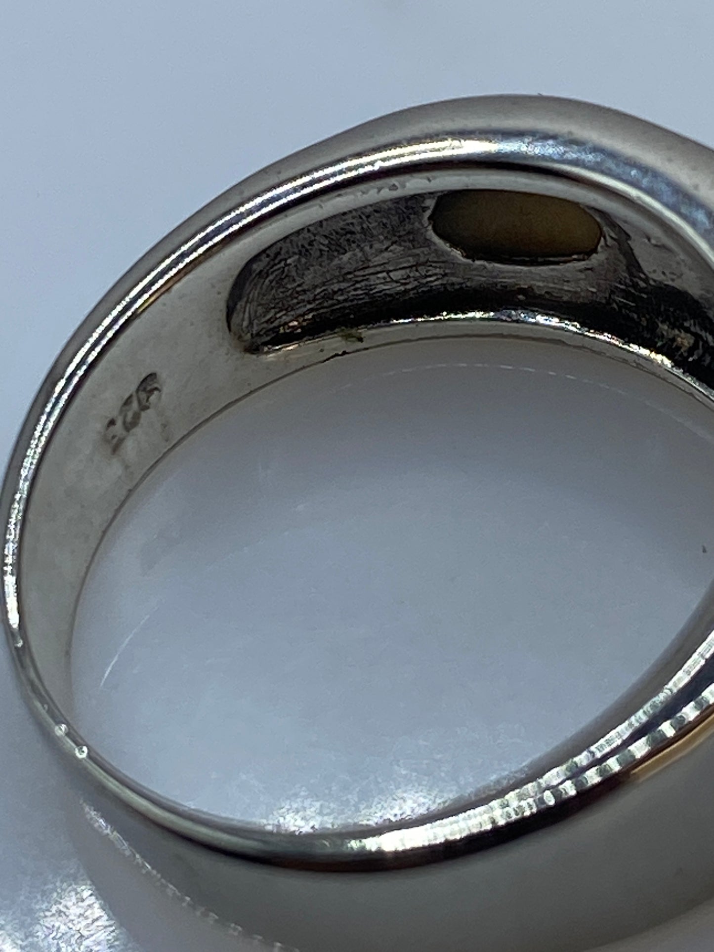 Anillo de ópalo en la mano mostrando el movimiento de luz en la piedra