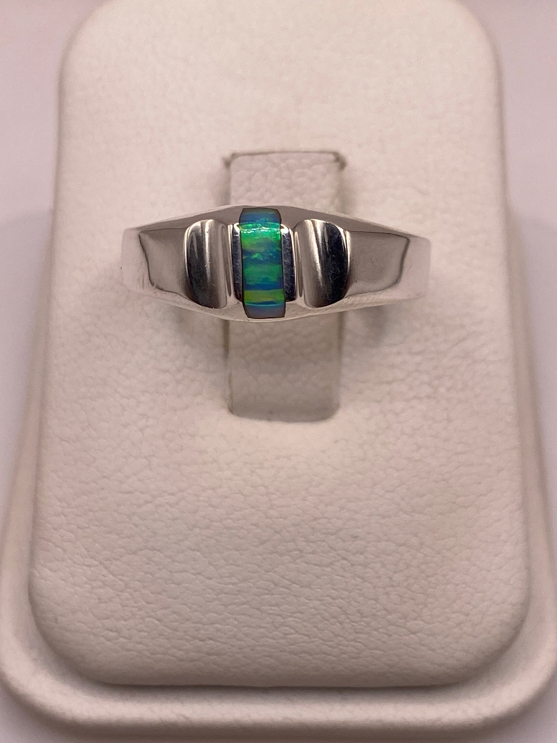 Anillo de plata con ópalo de fuego azul cielo en bandas geométricas, vista frontal en dedo