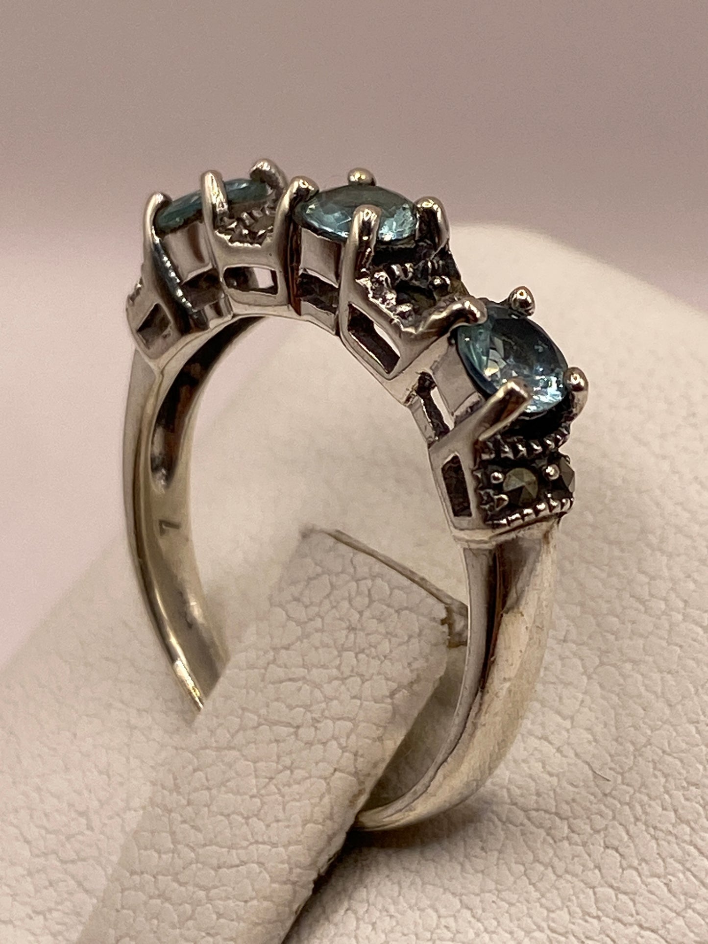 Anillo solitario de plata visto desde arriba, con el sello 925 visible en la banda