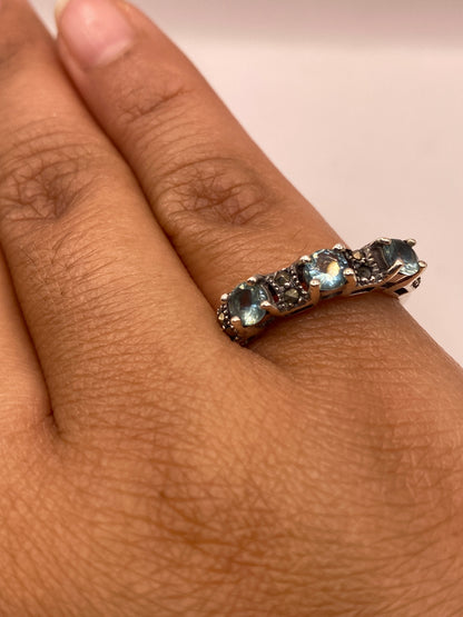 Anillo de plata con circonia azul puesto en la mano de una mujer, mostrando el brillo de la piedra