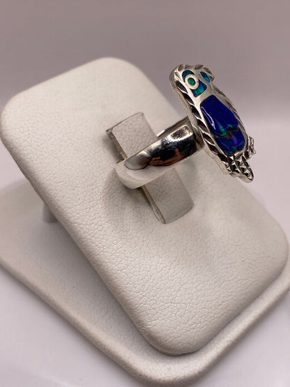 Vista frontal del anillo mostrando el juego de colores azul y verde del ópalo