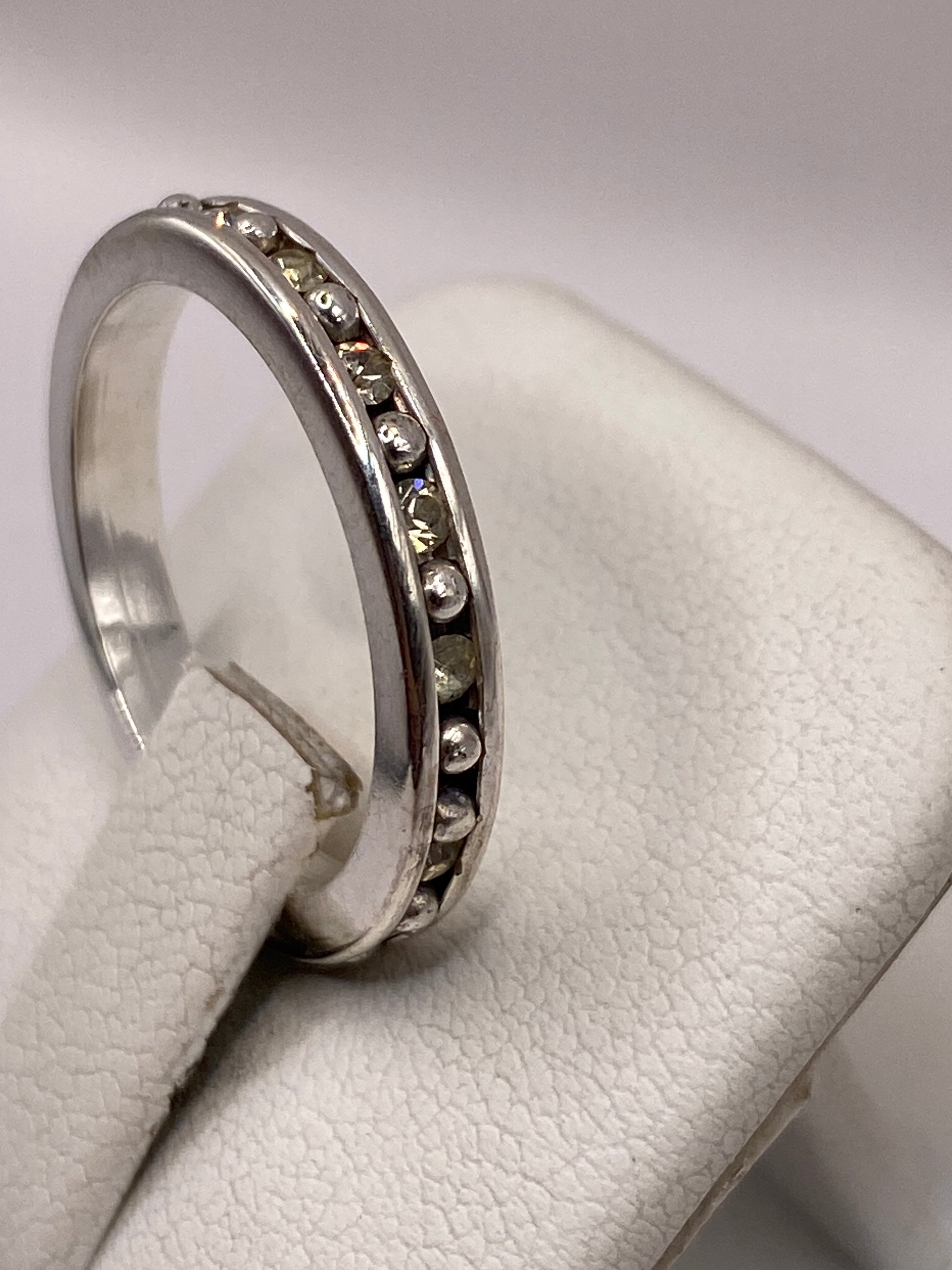 Detalle del anillo de banda mostrando las circonias amarillas engastadas a mano