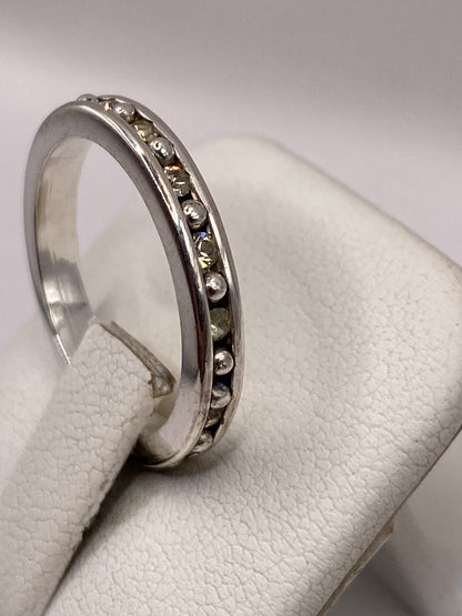 Detalle del anillo de banda mostrando las circonias amarillas engastadas a mano