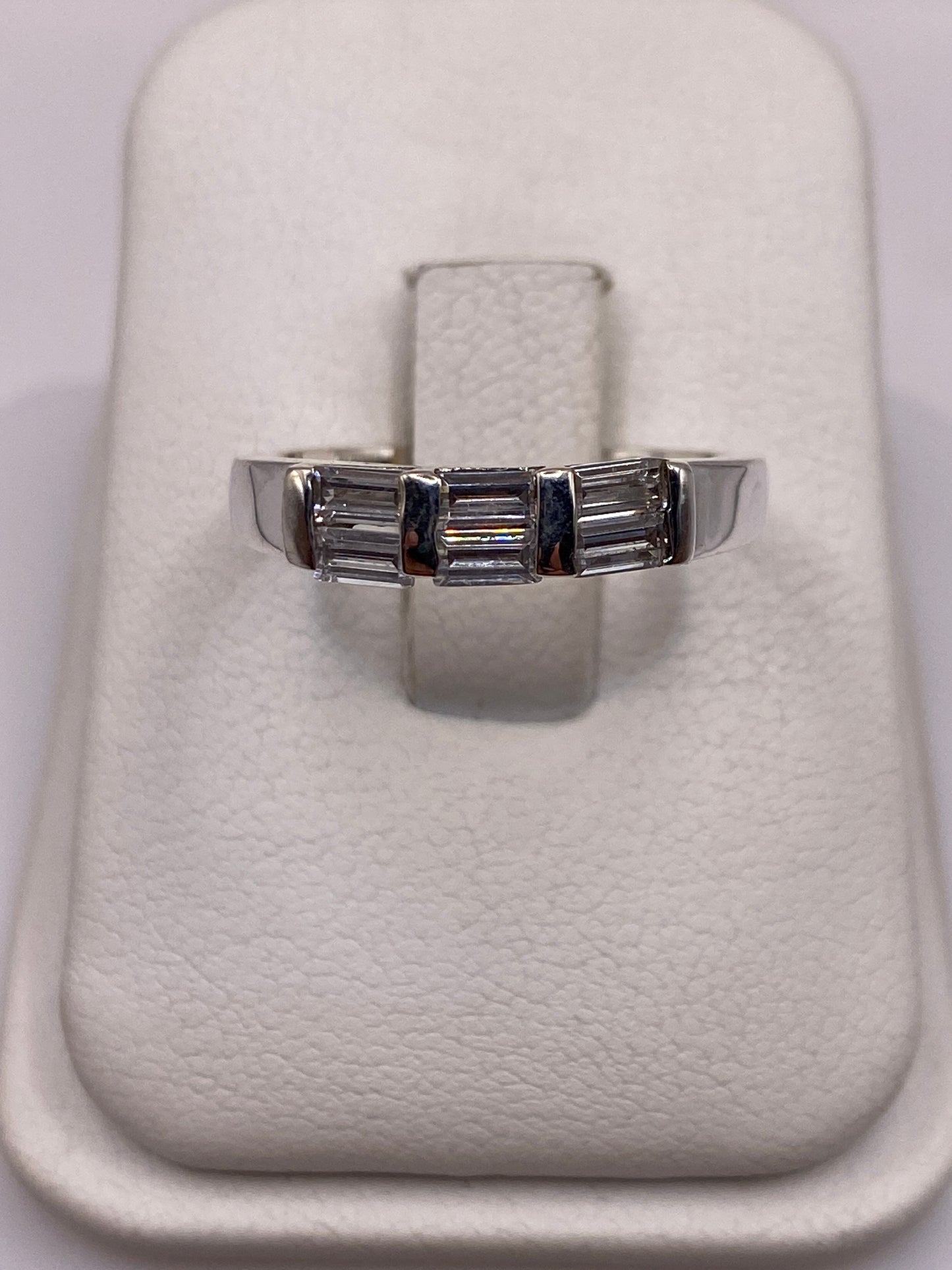 Anillo de plata solitario con circonia blanca brillante en la mano de una mujer