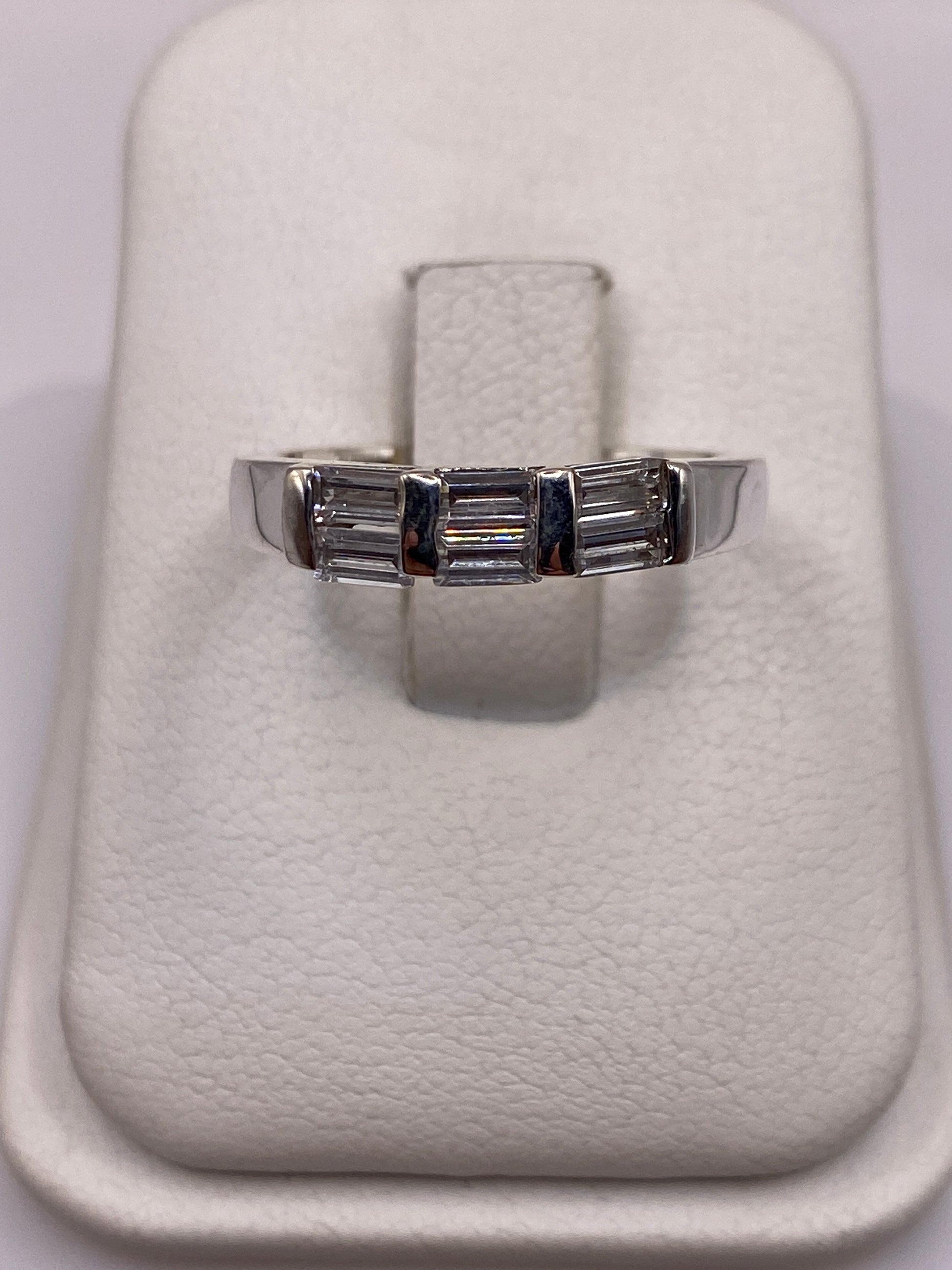 Anillo de plata solitario con circonia blanca brillante en la mano de una mujer