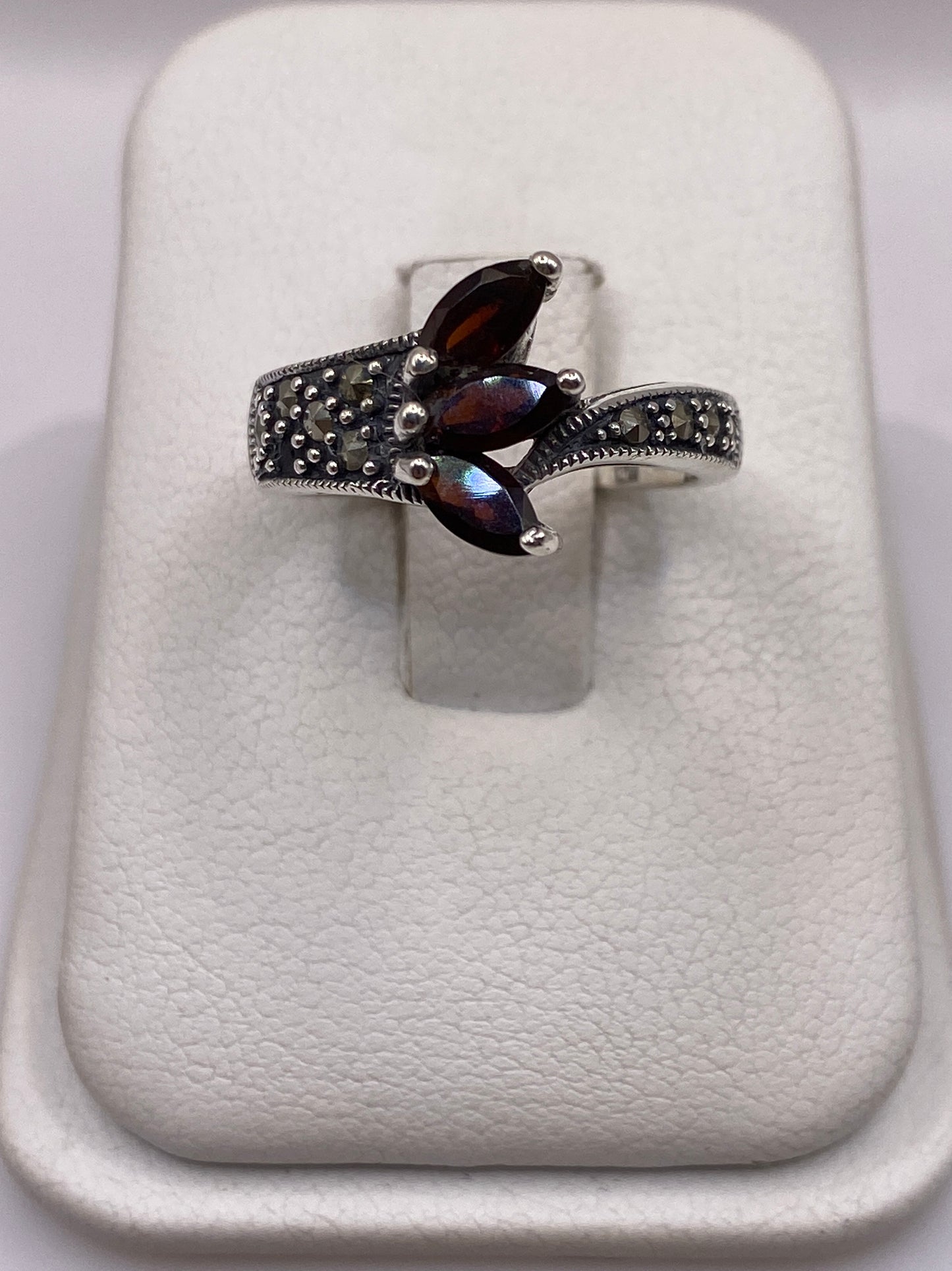 Anillo de plata .925 con circonia café en engaste de tres puntos sobre banda texturizada, visto de frente