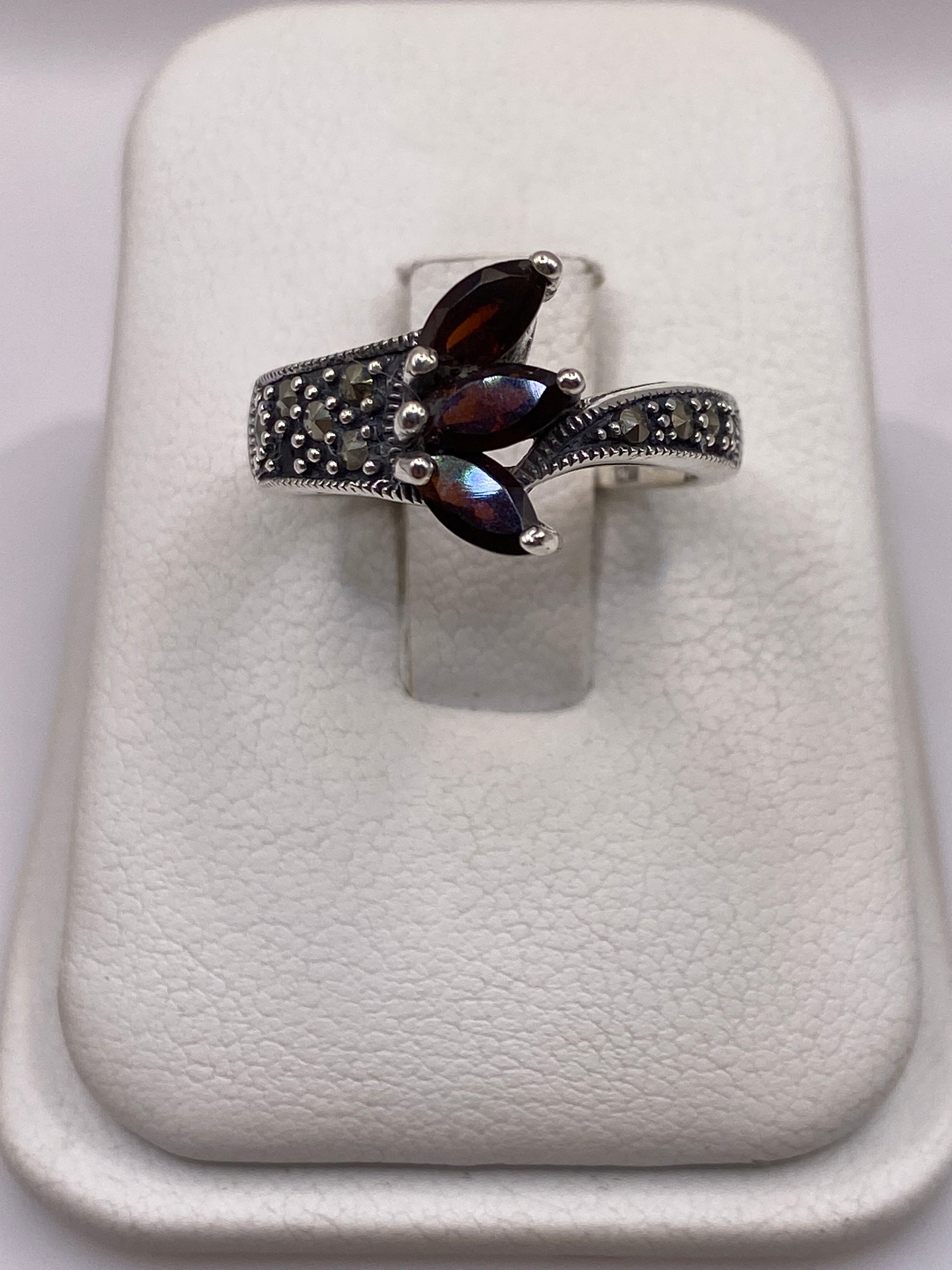 Anillo de plata .925 con circonia café en engaste de tres puntos sobre banda texturizada, visto de frente