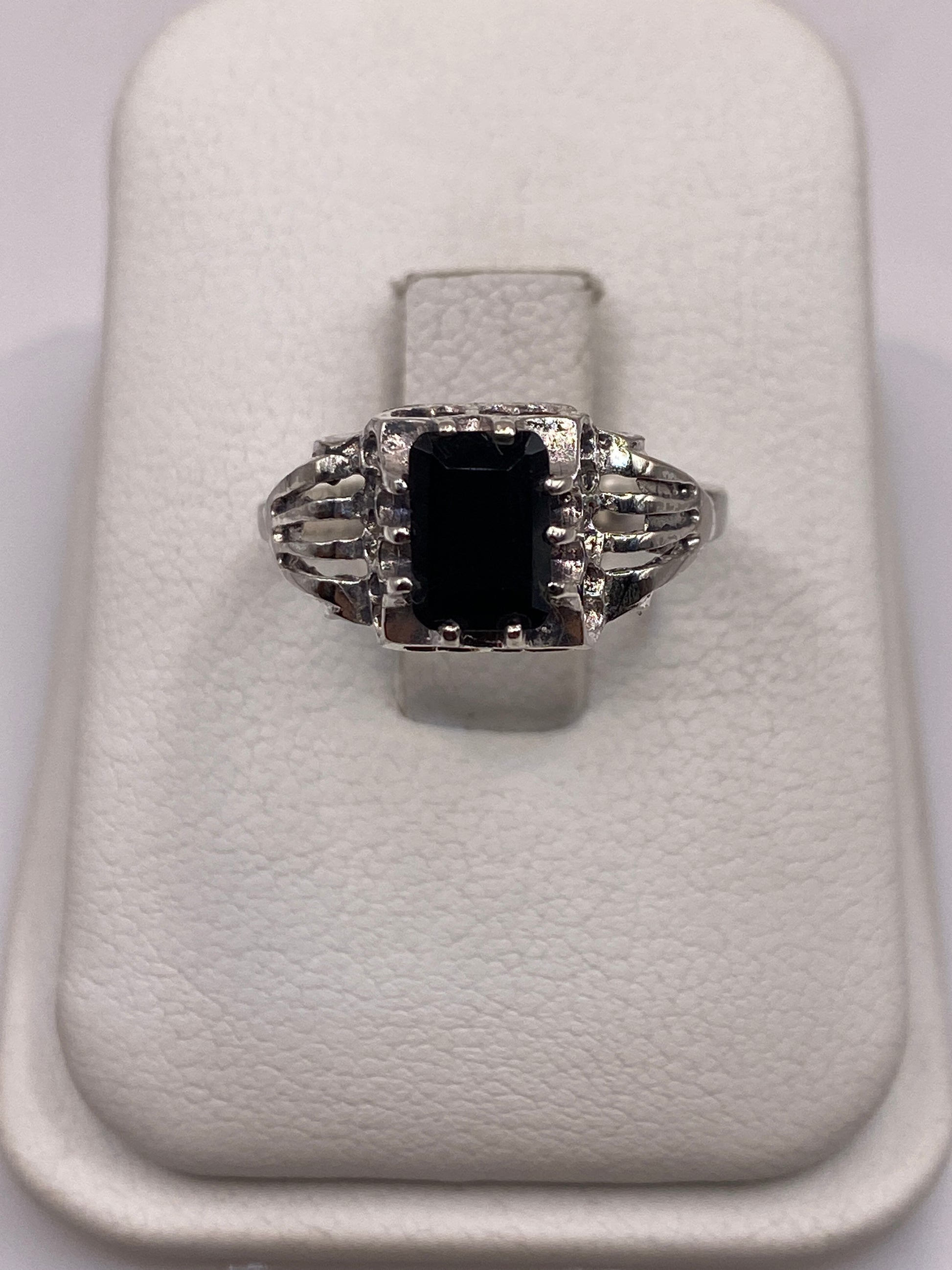 Anillo solitario de plata con circonia negra brillante en la mano