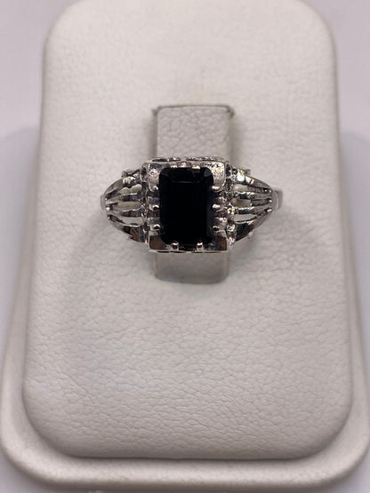 Anillo solitario de plata con circonia negra brillante en la mano