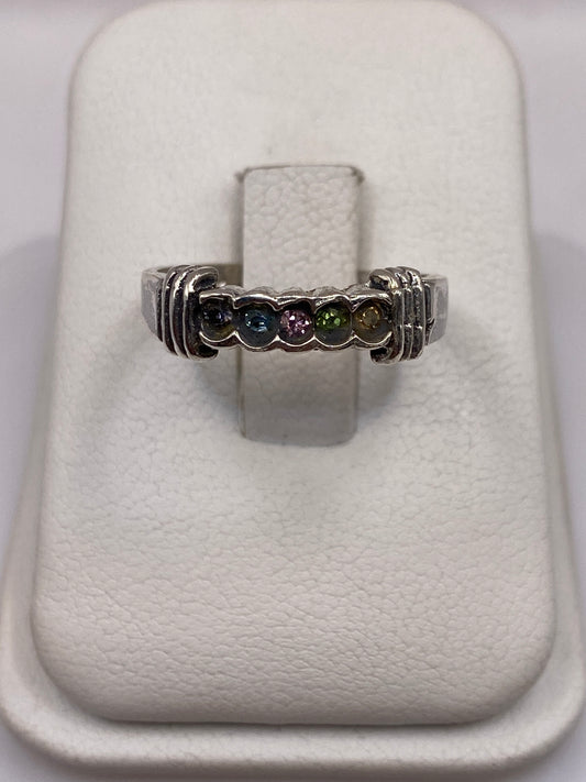 Anillo de plata solitario con circonia multicolor (azul, rosa, verde) en dedo de mujer