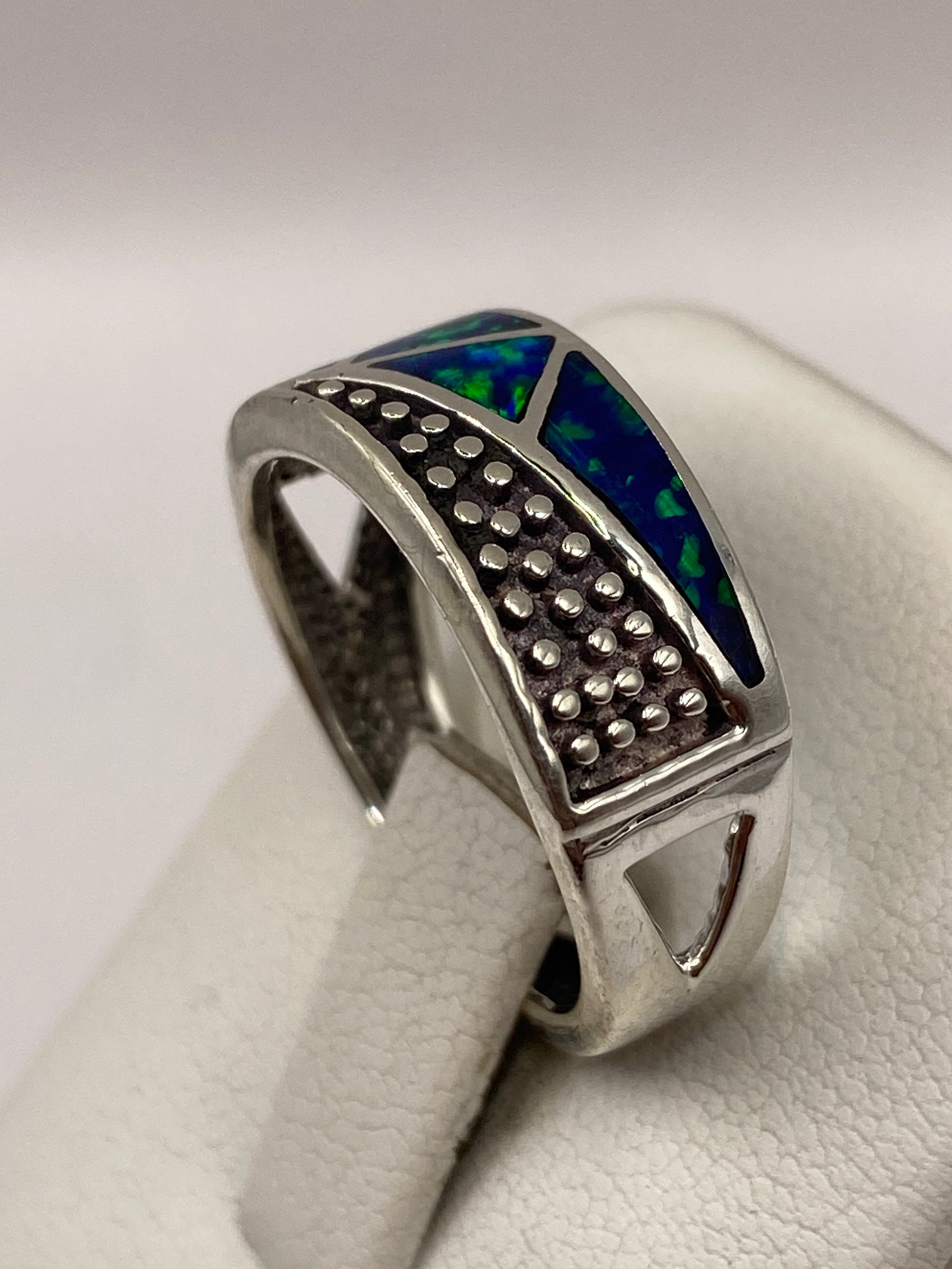 Ópalo de fuego azul con destellos verdes en el engaste de plata pura
