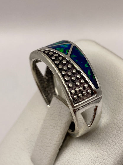 Ópalo de fuego azul con destellos verdes en el engaste de plata pura