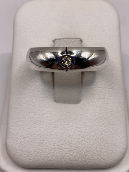 Anillo de plata solitario banda pulida con circonia en la mano de un hombre