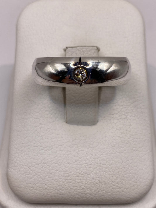 Anillo de plata solitario banda pulida con circonia en la mano de un hombre