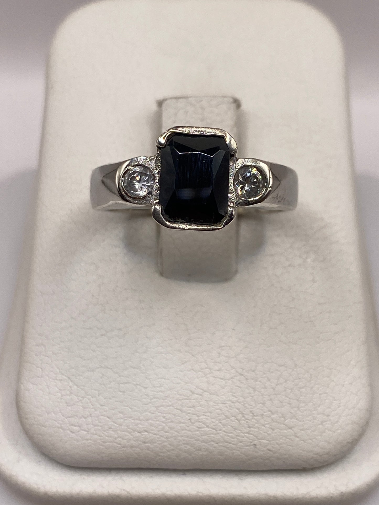 Anillo de plata solitario con circonia negra brillante, vista frontal sobre soporte blanco
