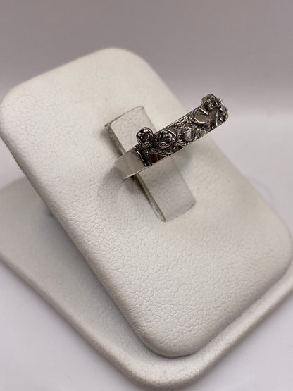 Anillo minimalista de plata .925 con piedra blanca, mostrado en dedo con piel morena