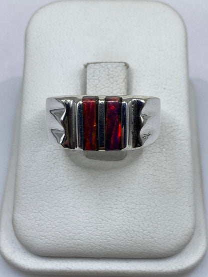 Anillo de plata con ópalo de fuego multicolor en estuche blanco sobre fondo neutro