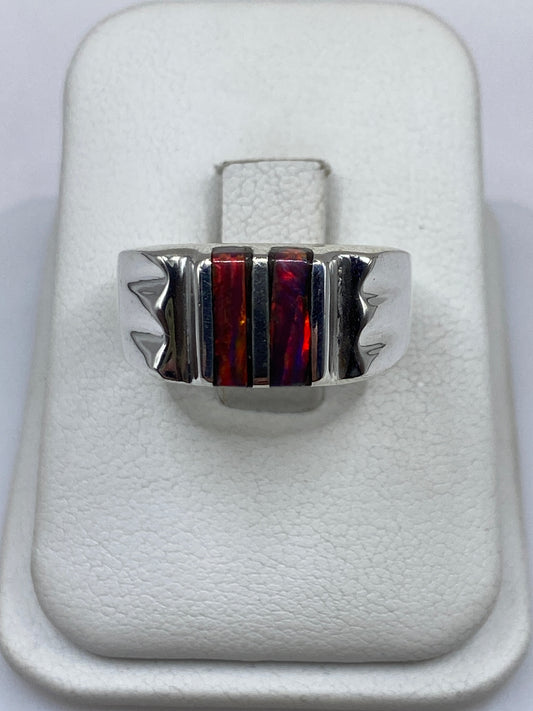 Anillo de plata con ópalo de fuego multicolor en estuche blanco sobre fondo neutro
