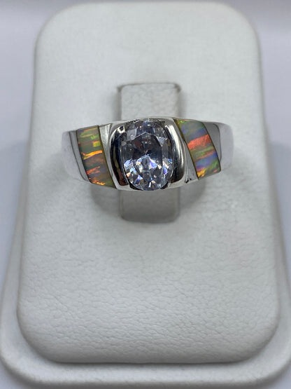Anillo de plata .950 con ópalo de fuego multicolor en mano mostrando juego de colores naturales
