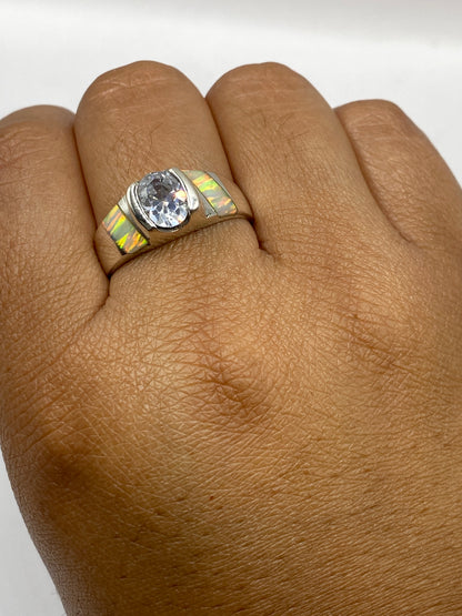 Anillo sobre fondo blanco con ópalo de fuego brillando en tonos naranja, amarillo y verde